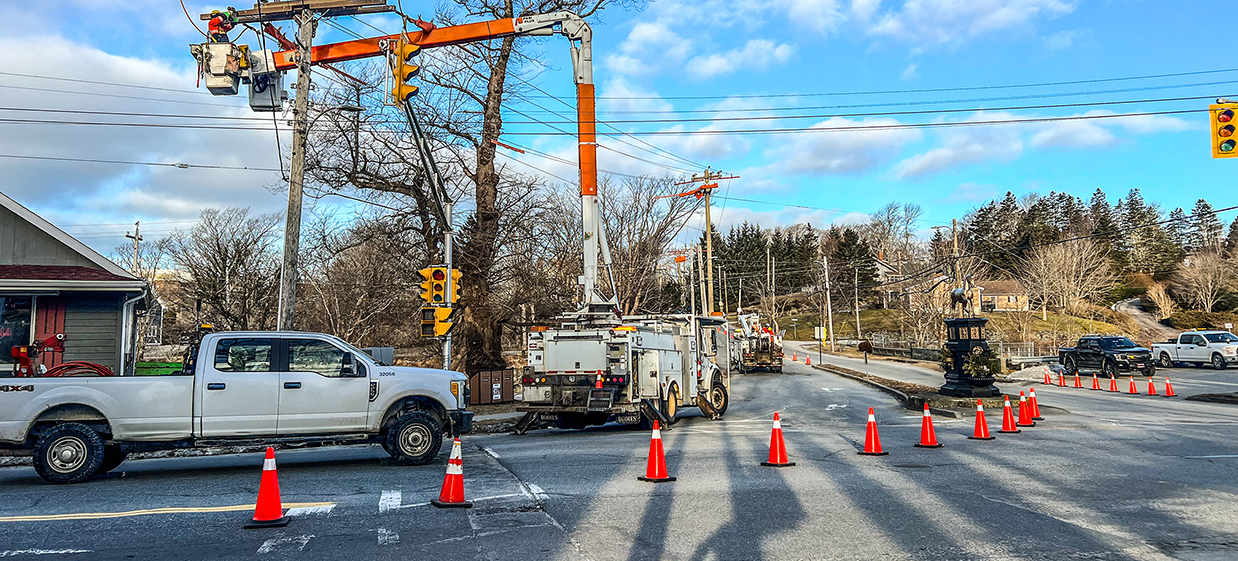 Blacktop Traffic Service work zone with traffic control vehicles and safety cones on Nova Scotia road