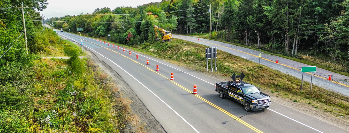 Blacktop Traffic Service truck with traffic cones and lane closure on Nova Scotia highway