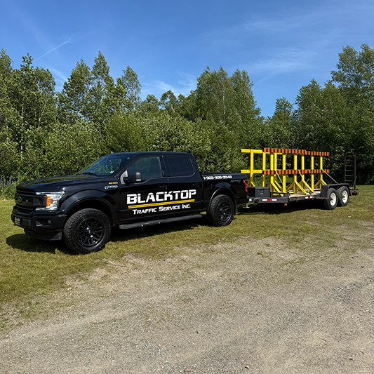 Blacktop Traffic Service truck with trailer and barricades