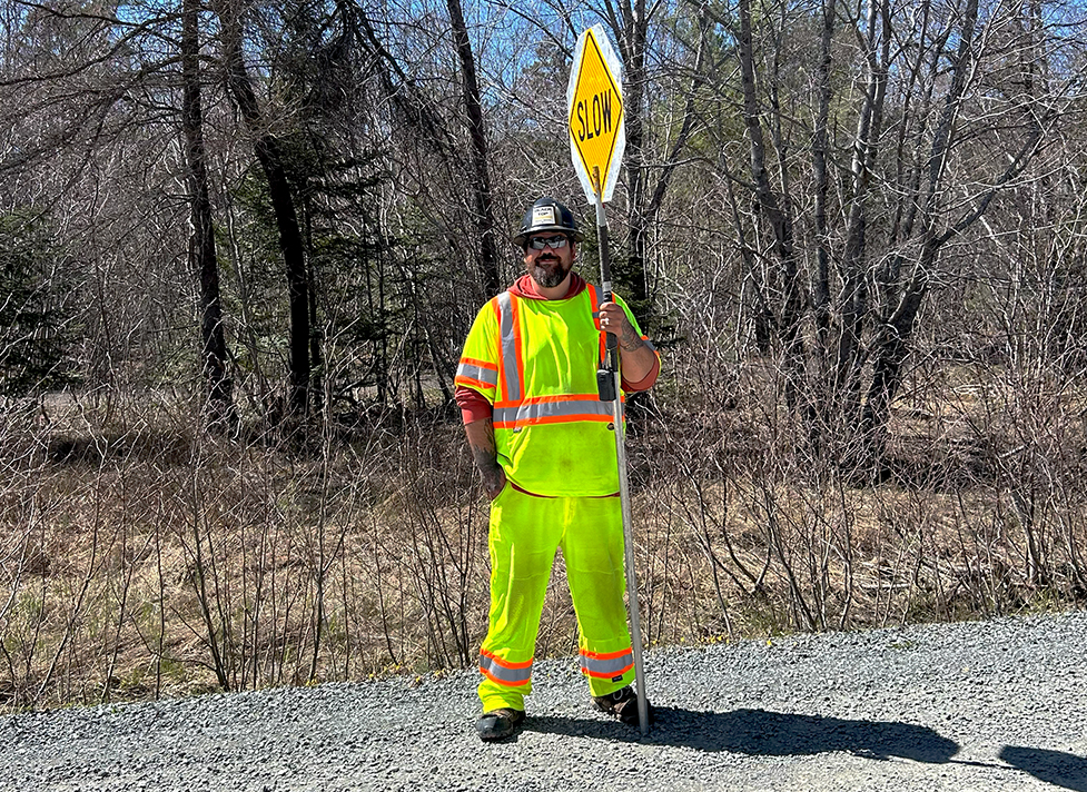 Traffic control person holding a slow sign at a work zone