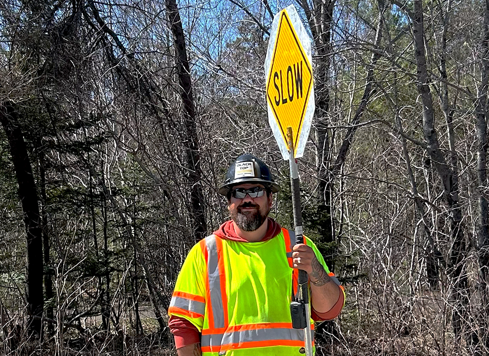 Traffic control person holding a slow sign at a work zone